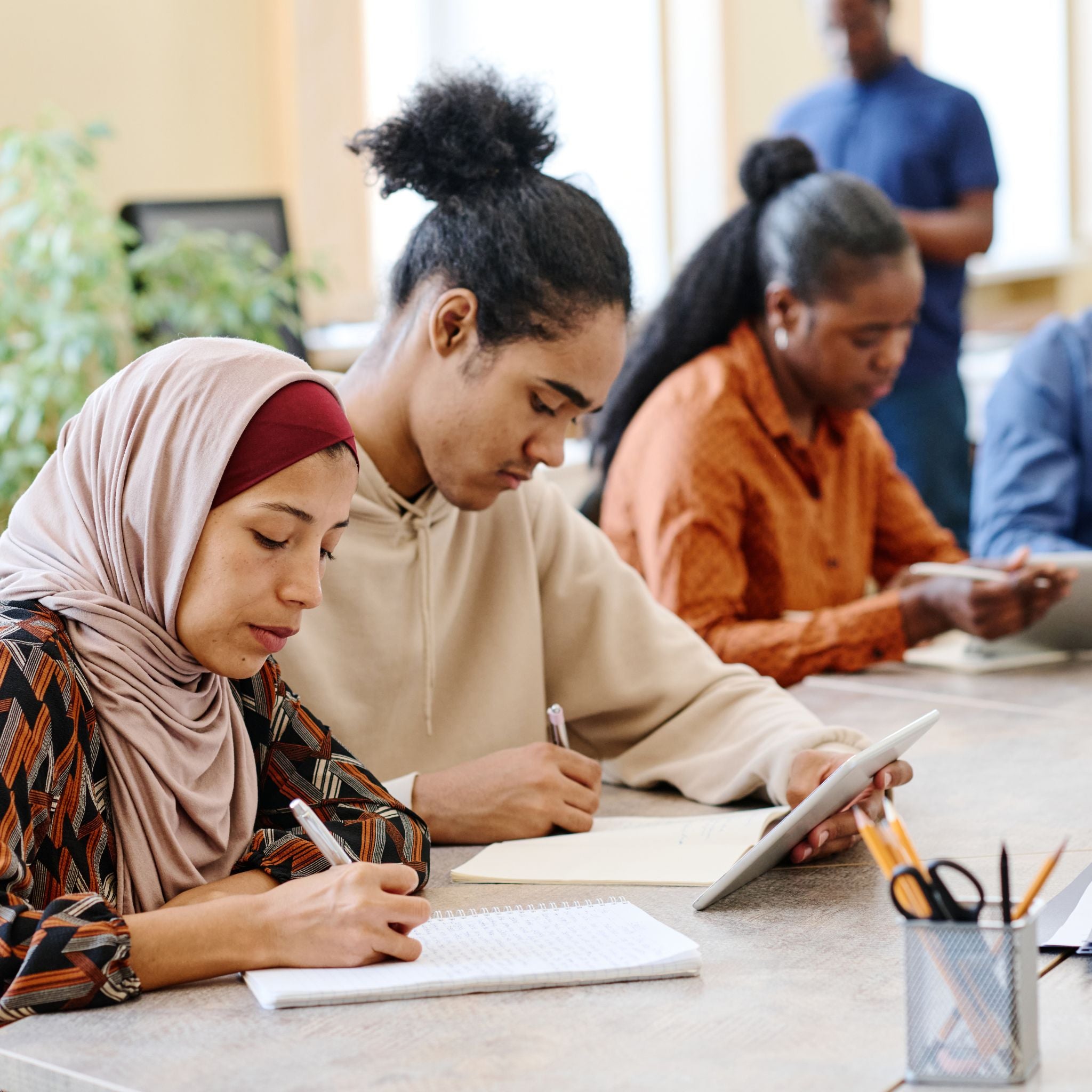 Two people writing in a table 