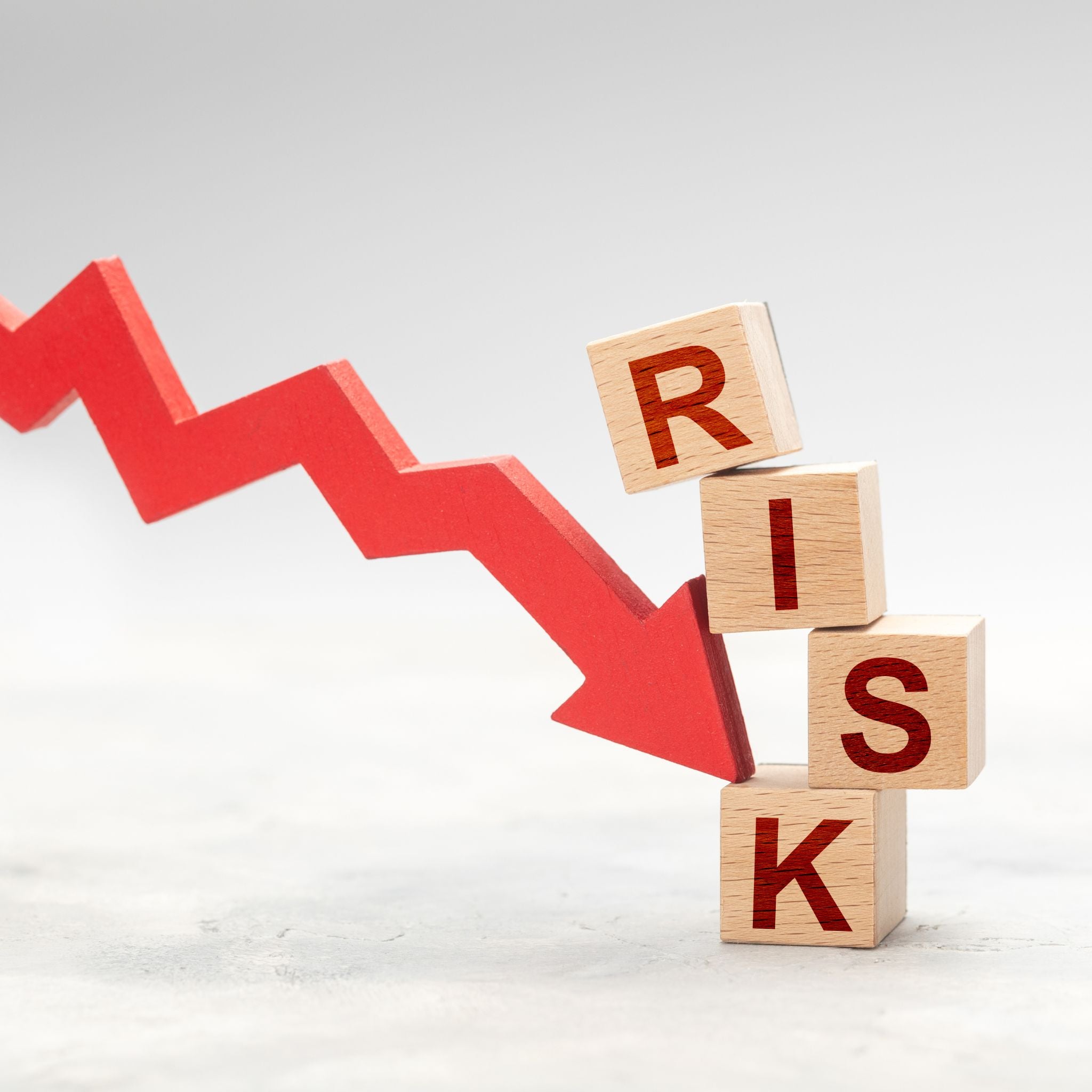 Red arrow pointing down next to wooden blocks spelling 'RISK'