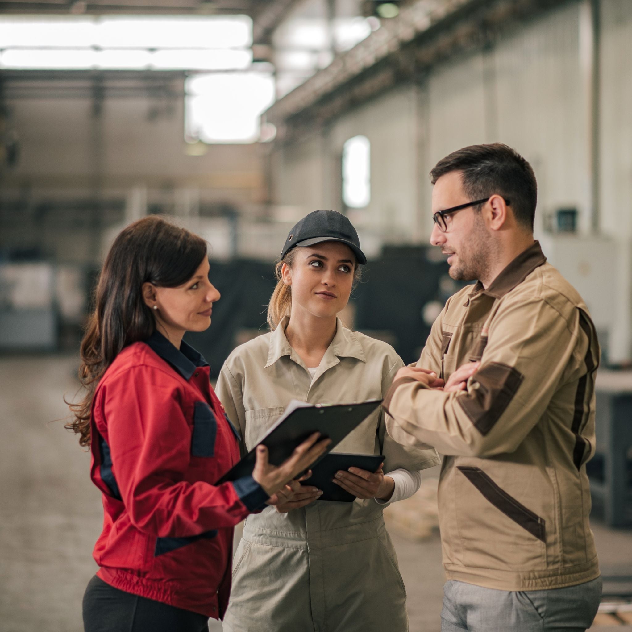 Three workers discussing in a warehouse